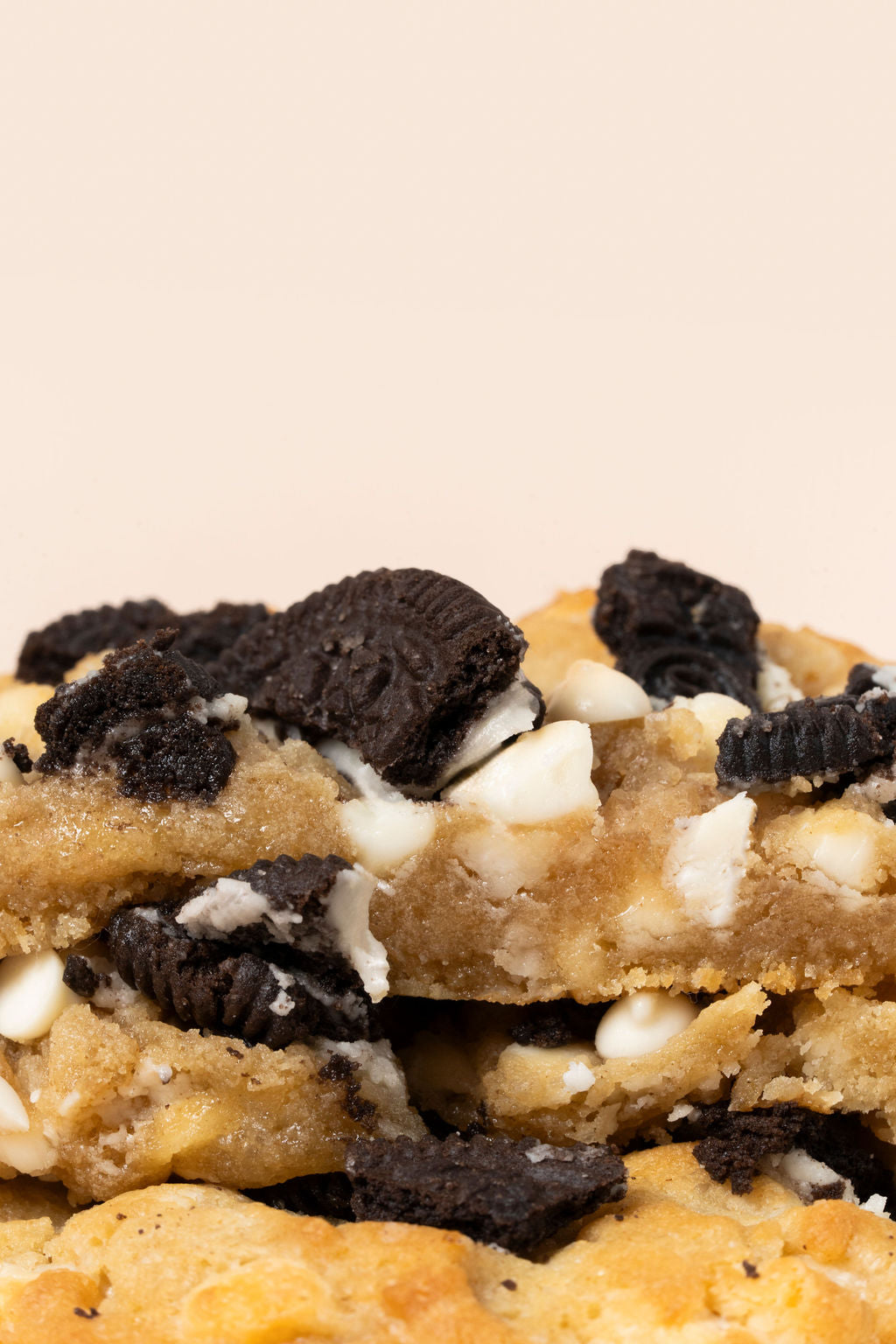 Galletas de Cookies and cream apiladas con chispas de chocolate blanco y trozos de oreo con una corteza crujiente y un centro suave