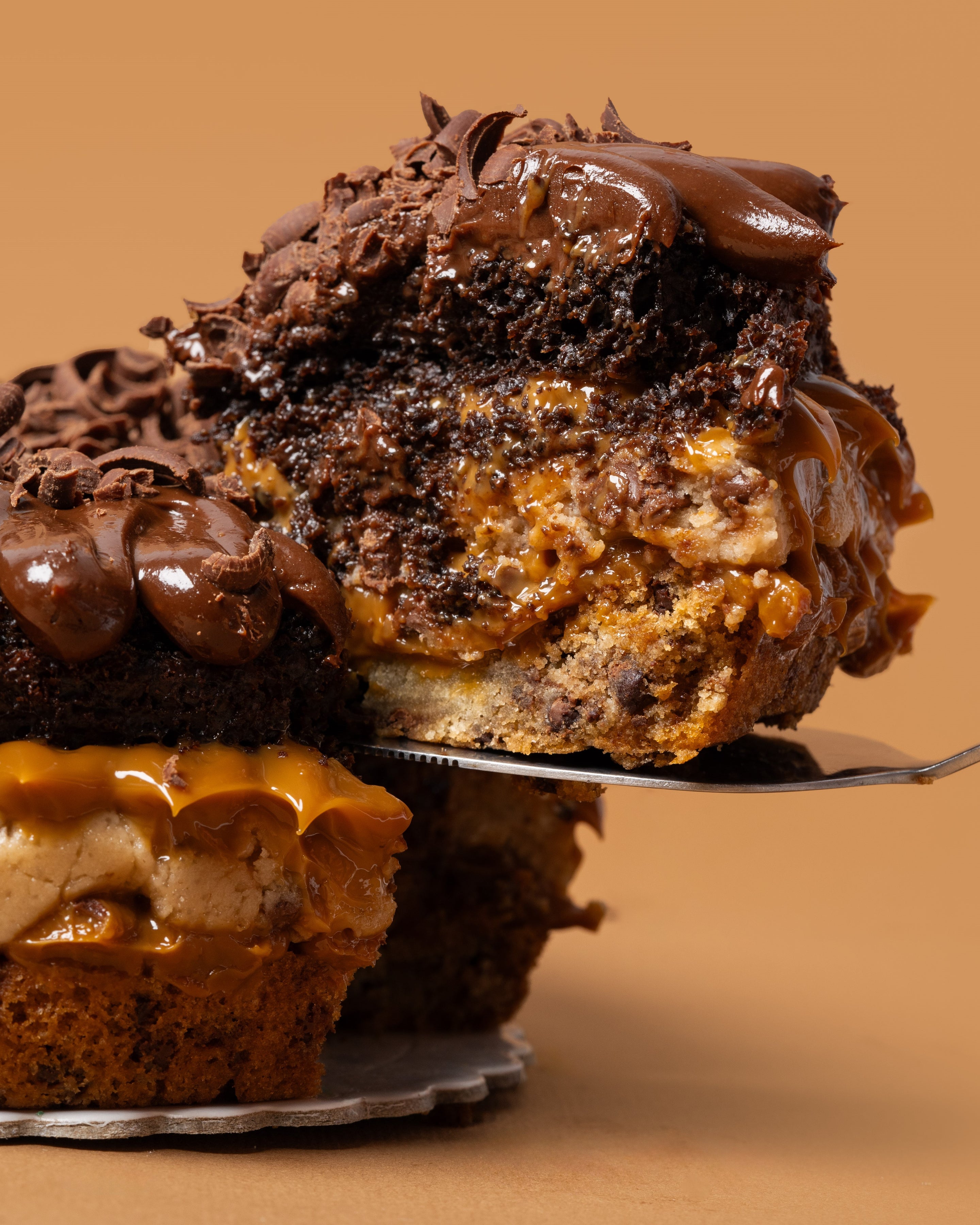 Tajada d torta apetitosa con una capa de la masa de Cheweez, una capa de cookie dough y seguido de una capa de torta de chocolate con relleno de manjar de olla