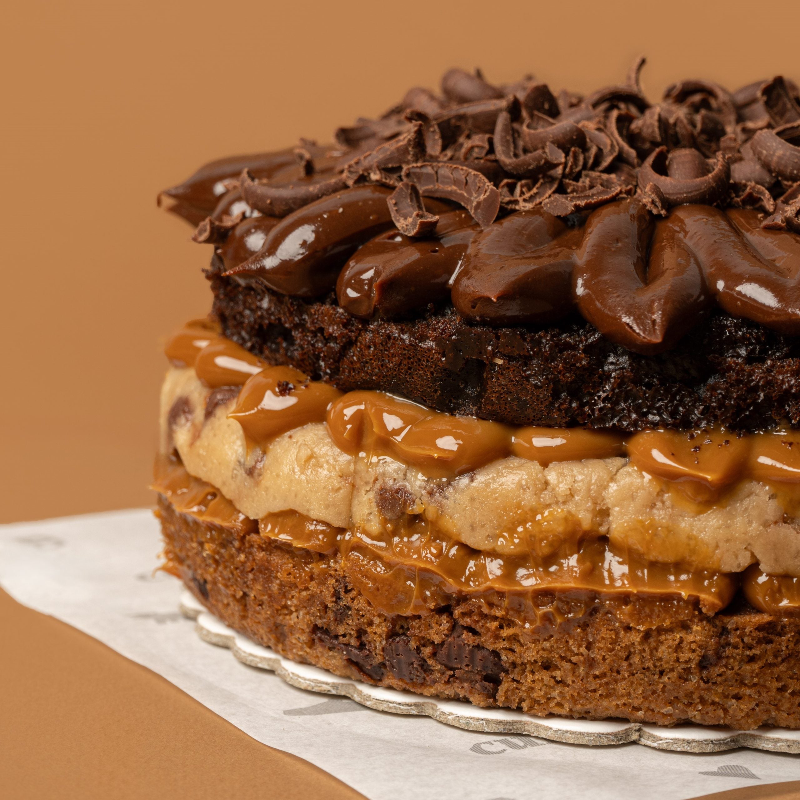 Torta con una capa de masa Cheweez, seguida de una generosa capa de cremoso cookie dough, y coronada con una capa de torta de chocolate.